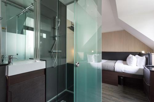 伦敦Z酒店维多利亚的一间带玻璃淋浴间和床的浴室