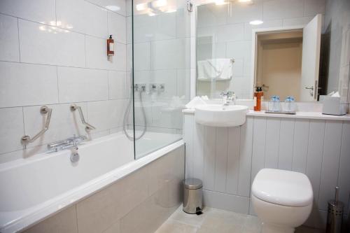 邓格洛Waterfront Hotel Dungloe的浴室配有卫生间、盥洗盆和淋浴。