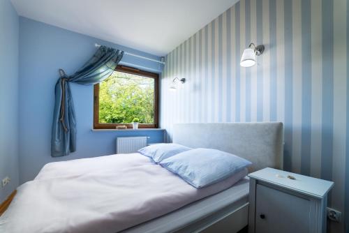 加茨比亚格拉Apartament Rozgwiazda的蓝色的卧室设有床和窗户