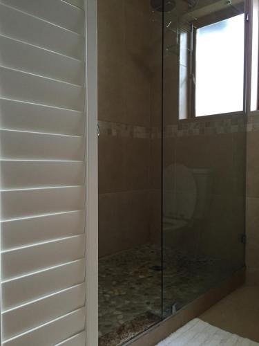 普利登堡湾Keurbooms River Lodge 1311的浴室里设有玻璃门淋浴