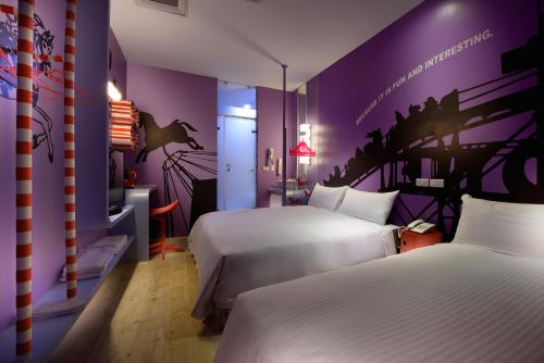 高雄NL概念商旅的一间卧室设有两张床和紫色的墙壁