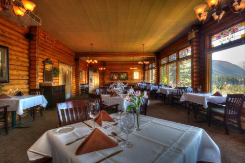 贾斯珀跨海山旅舍的一间设有白色桌椅和窗户的用餐室