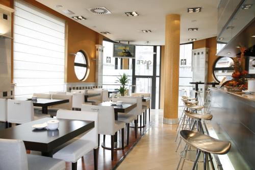 米耶雷斯米耶雷斯德尔卡米诺酒店 的一间带白色桌椅和柜台的餐厅