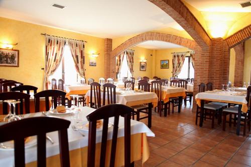 Villalón de CamposHotel Rural Venta Del Alon的餐厅设有白色的桌椅和窗户。
