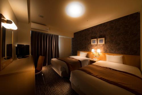 藤泽湘南藤泽法华俱乐部酒店的酒店客房设有两张床和电视。