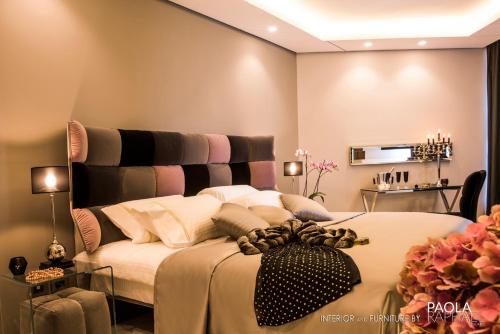 贝鲁特阿什拉菲耶皇家郁金香酒店的一间卧室配有一张大床和黑色床头板