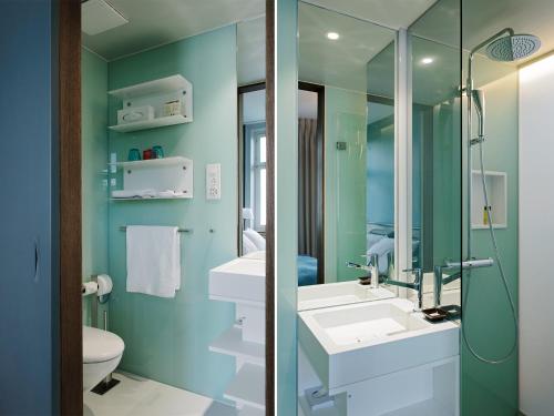苏黎世普拉特恩霍夫设计酒店的一间带两个水槽和玻璃淋浴间的浴室