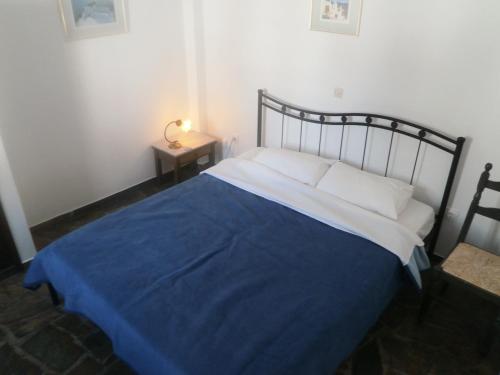 卡马利奥斯特里亚别墅酒店的一间卧室配有一张带蓝色毯子的床