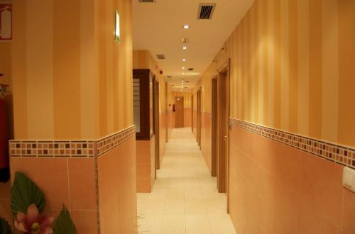 毕尔巴鄂左拉兹艾1宾馆的走廊位于带木墙和瓷砖地板的建筑内