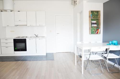 布鲁塞尔大广场附近辛巴公寓的厨房配有白色橱柜和桌椅