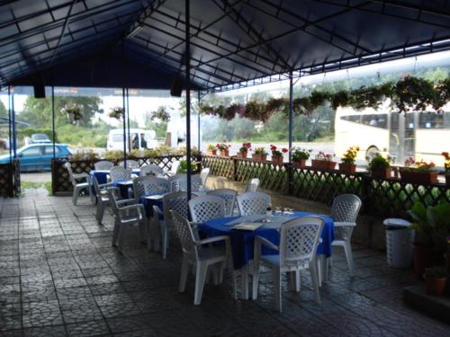 Băicoi帕拉勒拉45 旅游大厦旅馆的一组桌子和白色椅子,配蓝色桌子