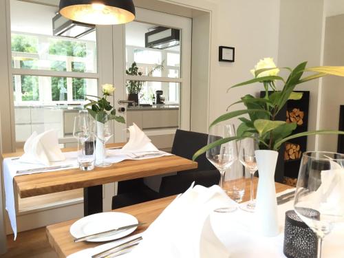 阿尔岑瑙·因·尤特弗兰恩斯特芬赫内姆赫酒店的用餐室配有带白板和玻璃杯的木桌