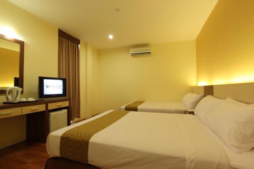 关丹季节景观酒店的酒店客房,配有床和电视