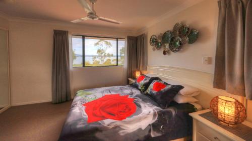帝坎湾海豚沃特酒店的一间卧室,床上有红玫瑰