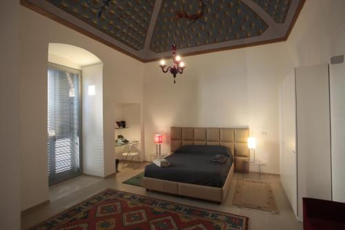 巴里普利亚涅槃公寓的一间卧室配有一张床和一个吊灯
