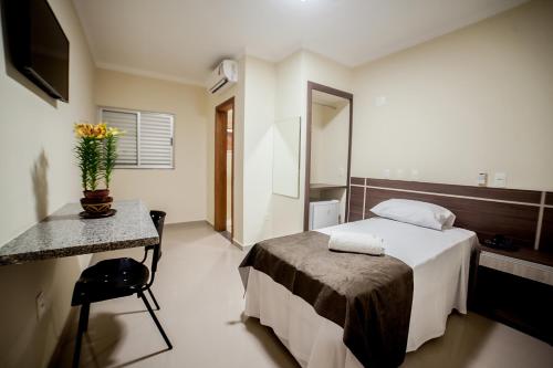 库亚巴Apoema Hotel的酒店客房配有床、桌子和镜子