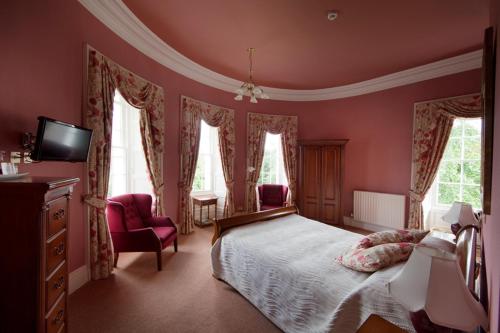 巴森斯韦特水上会馆酒店的一间卧室设有粉红色的墙壁、一张床和电视