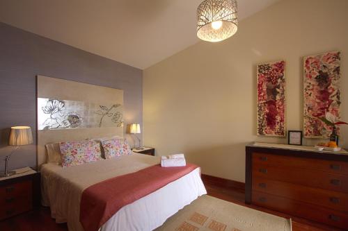 Madalena do MarSunset Sea Breeze的一间卧室配有床、梳妆台和台灯。