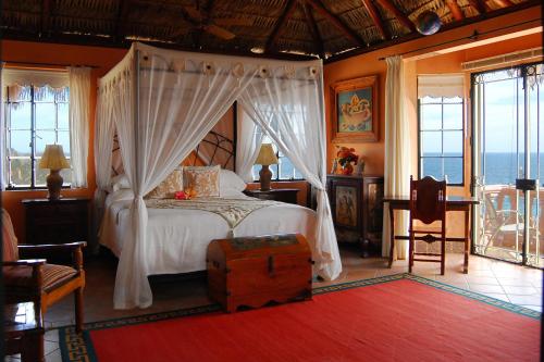 Boca de la Vinorama德尔法鲁旅馆的一间卧室设有一张天蓬床,享有海景