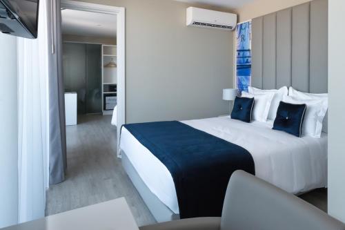 里斯本里斯本圣本托酒店的酒店客房配有一张带蓝色枕头的大床