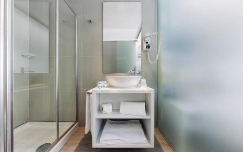里斯本里斯本圣本托酒店的一间带水槽和玻璃淋浴的浴室