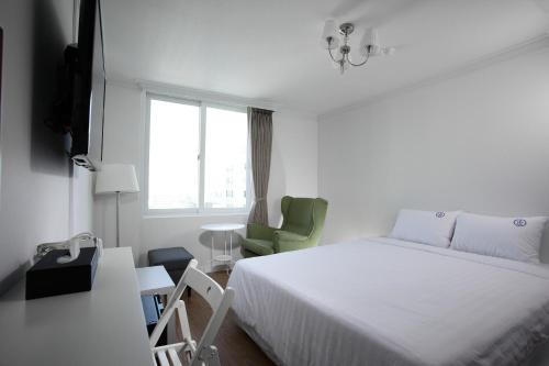 釜山山坡酒店的白色的卧室设有床和窗户