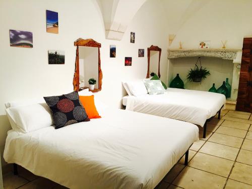 马丁纳弗兰卡B&B Palazzo Giorgi的配有白色床单的客房内的两张床