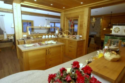 巴特彼得斯塔尔Hotel zum Breitenberg的厨房配有木制橱柜和红色鲜花的柜台