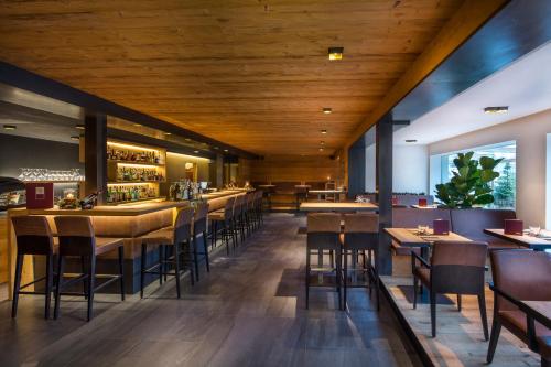 拉维拉Hotel Cristallo - Wellness Mountain Living的餐厅设有木制天花板和桌椅