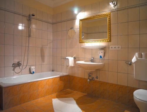 Unterauerling老朋友汽车旅馆的带浴缸、水槽和镜子的浴室
