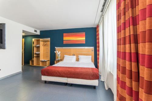 罗马Sotel Nomentana Roma的一间卧室配有一张带红色毯子的床