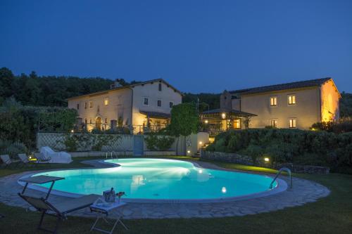 巴尼奥维尼奥尼Relais Osteria Dell'Orcia的夜间在房子的院子中的一个游泳池