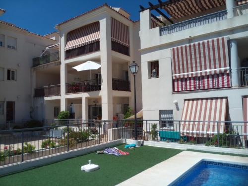 贝纳尔马德纳Casa Joca Pueblo的公寓大楼设有游泳池和庭院。