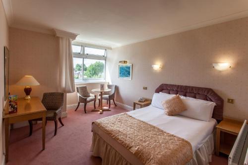 伦敦大不列颠汉普斯蒂德酒店的酒店客房带一张床、一张桌子和椅子