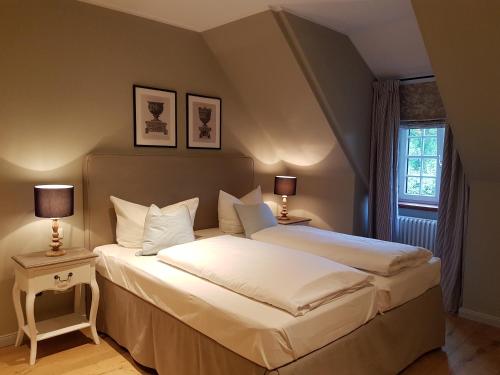 普拉特灵胡特优质旧木乡村餐厅酒店的一间卧室配有两张床和两盏灯。