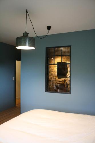 PresseuxLa lune en bulles的一间卧室设有蓝色的墙壁和窗户。