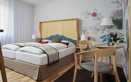 古坦泽尔赫贝尔Hotel Restaurant Klosterhof的卧室配有一张床和一张桌子及椅子