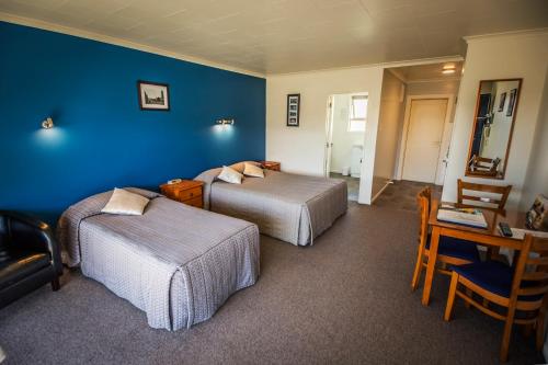 奥玛鲁AAA 泰晤士阁汽车旅馆的一间卧室设有两张床和蓝色的墙壁
