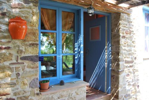 卡法斯Villa Spiti Elaionas的石头房子的蓝色门,有窗户