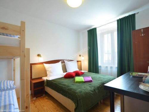 斯维诺乌伊希切Moniuszki24的一间卧室配有带绿色床单和红色枕头的床
