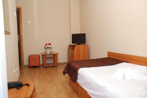 克卢日-纳波卡丽丽阿西尔酒店的一间卧室配有一张床和一台电视