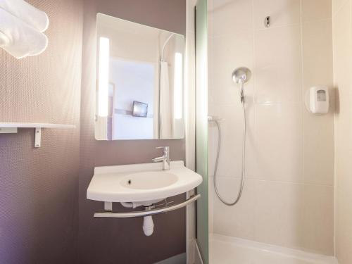 布西圣乔治B&B HOTEL Marne-la-Vallée Bussy-Saint-Georges的一间带水槽和淋浴的浴室