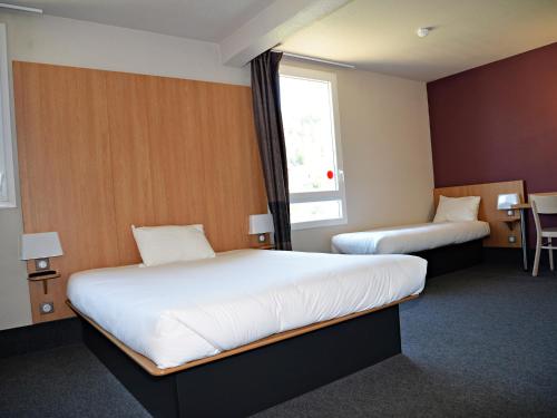 Saint-Martin-de-ValgalguesB&B HOTEL Alès - Pôle Mécanique的酒店客房设有两张床和窗户。