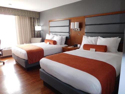 格林斯伯勒格林斯伯勒温德姆花园酒店的酒店客房设有两张床和窗户。