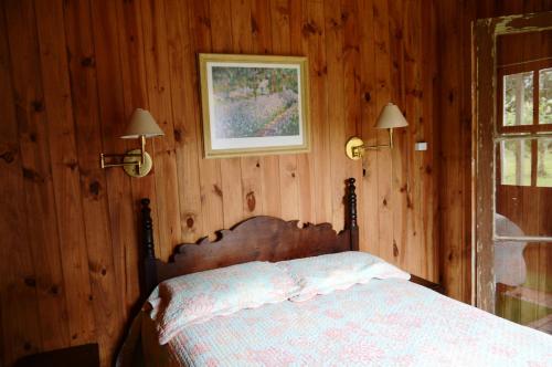TavaresAldeia Santuario das Aves的一间卧室配有一张木墙床