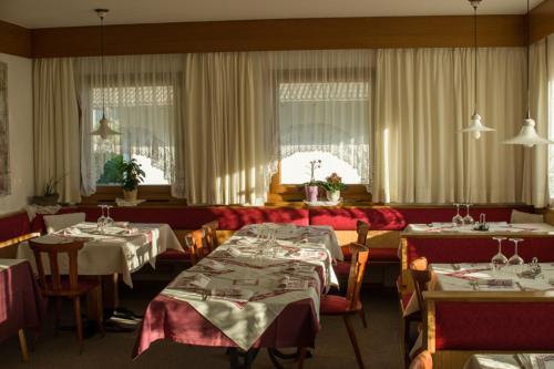 思科纳Pension Apartments Klotznerhof的一间带2张桌子和椅子的用餐室以及一间配有桌面的用餐室