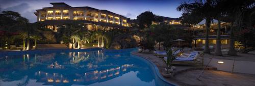 迪亚尼海滩迪亚尼礁石海滩Spa度假酒店的大楼前设有游泳池的酒店