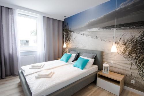 博格泽利卡Apartament Baltic Park - BEL MARE 2的一间卧室配有两张床,享有海滩美景。