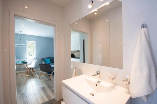 博格泽利卡Apartament Baltic Park - BEL MARE 2的白色的浴室设有水槽和镜子