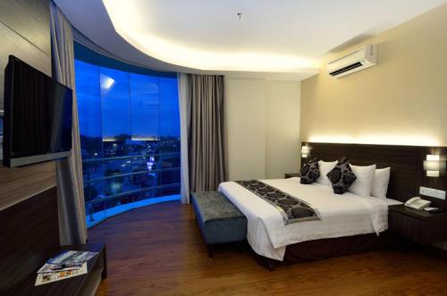 哥打巴鲁哥打巴鲁假日别墅套房酒店的酒店客房设有一张床和一个大窗户